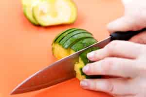 Free photo hands cutting cucumber