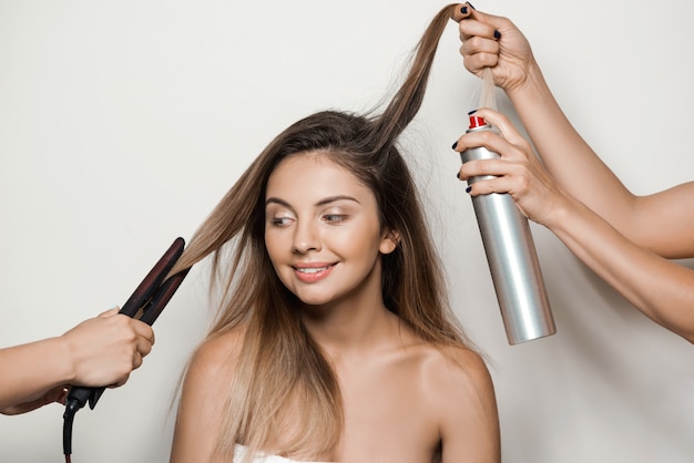 Free photo hands doing hairstyle to young beautiful woman