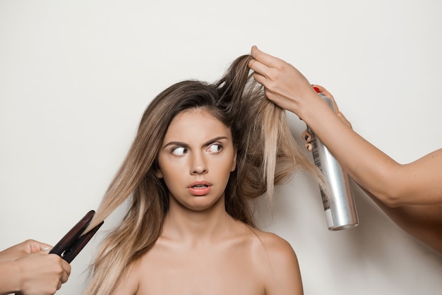 Hands doing hairstyle to young beautiful woman