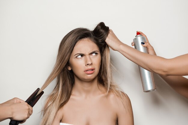 Hands doing hairstyle to young beautiful woman