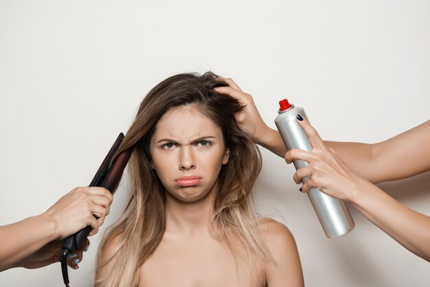 Hands doing hairstyle to young beautiful woman