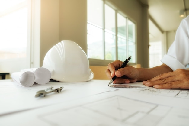 Hands of Engineer working on blueprint,Construction concept. Engineering tools.Vintage tone retro filter effect,soft focus(selective focus)