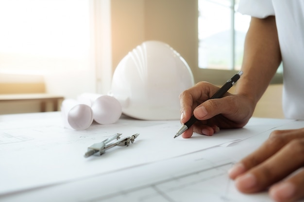 Hands of Engineer working on blueprint,Construction concept. Engineering tools.Vintage tone retro filter effect,soft focus(selective focus)