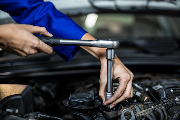 Foto gratuita mani di meccanico femminile la manutenzione di un auto