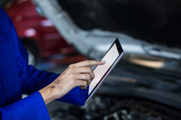 Hands of female mechanic using digital tablet