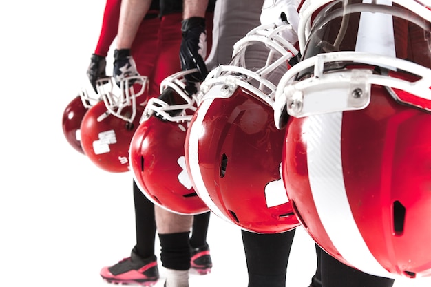 The hands of five american football players with helmets on white background