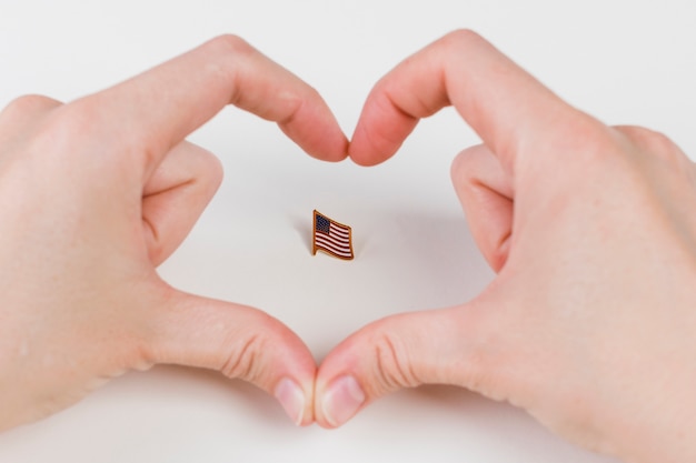 Foto gratuita mani che gesturing cuore e bandiera americana