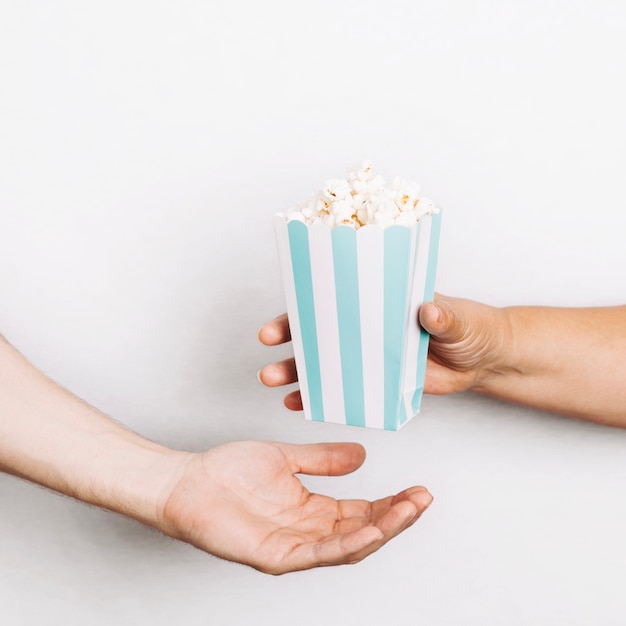 Free photo hands giving popcorn