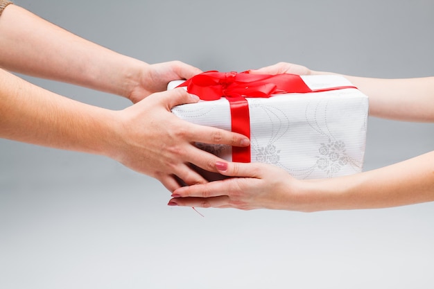 The hands giving and receiving a present on white background