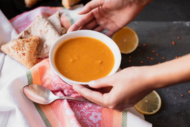 Hands grabbing a bowl of soup