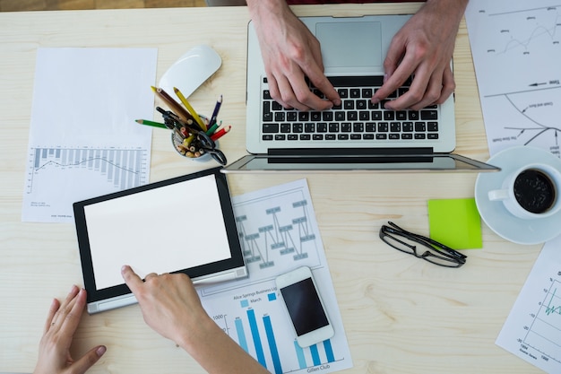 Hands of graphic designers using laptop and digital tablet