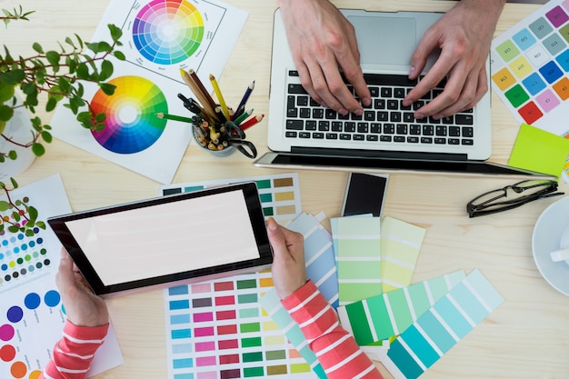 Foto gratuita mani di graphic designer con laptop e tablet digitale