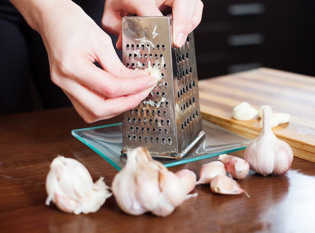 hands  grating garlic with grater