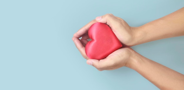赤いハートを持っている手。心臓の健康寄付の概念