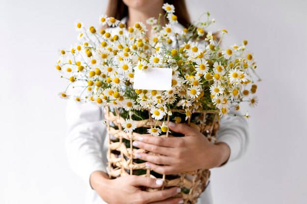 Hands holding basket with flowers close up