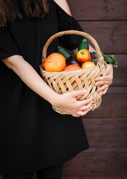 Hands holding basket with vegetables
