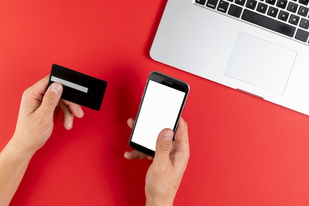 Hands holding a black card and a phone mock up