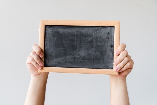 Hands holding blank blackboard