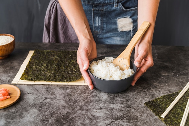 Hands holding bowl of rice