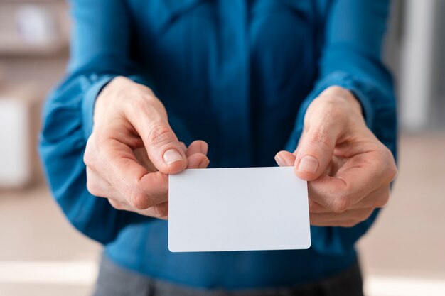 Hands holding business card high angle