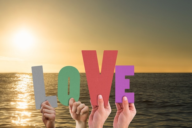 Free photo hands holding colorful letters at sunset