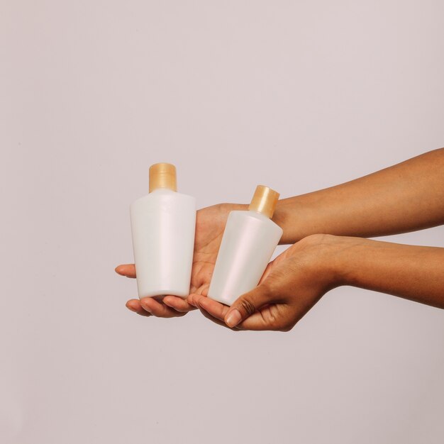 Hands holding cosmetic products