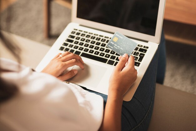 Hands holding a credit card and a laptop