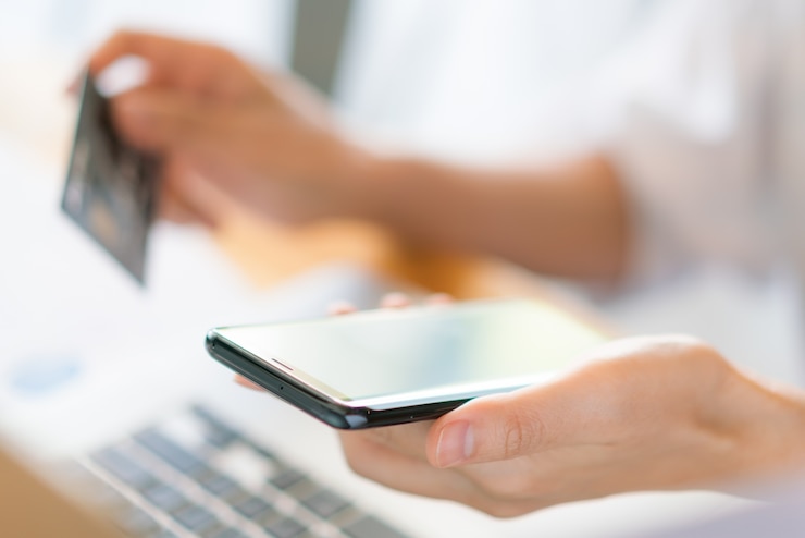 Free Photo hands holding a credit card using laptop computer and mobile phone for online shopping