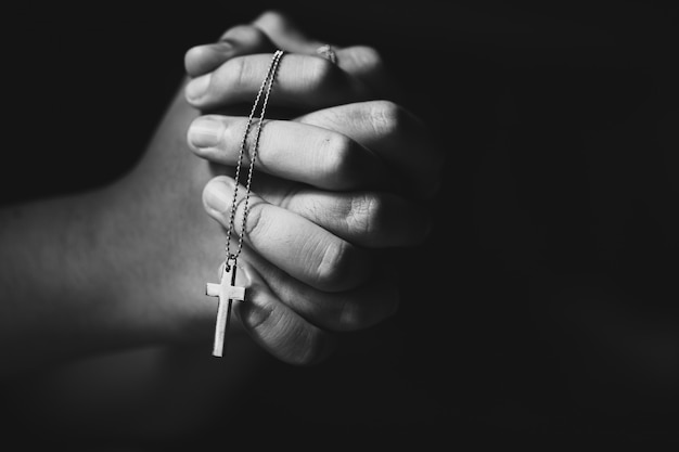 기도하는 동안 손을 잡고 십자가.