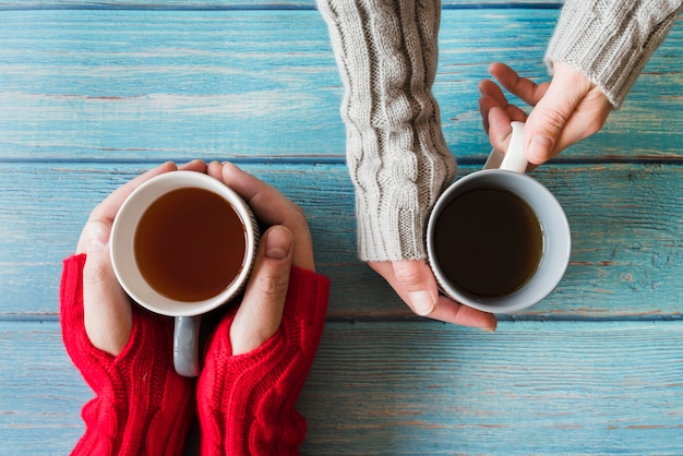 Free photo hands holding cups of tea