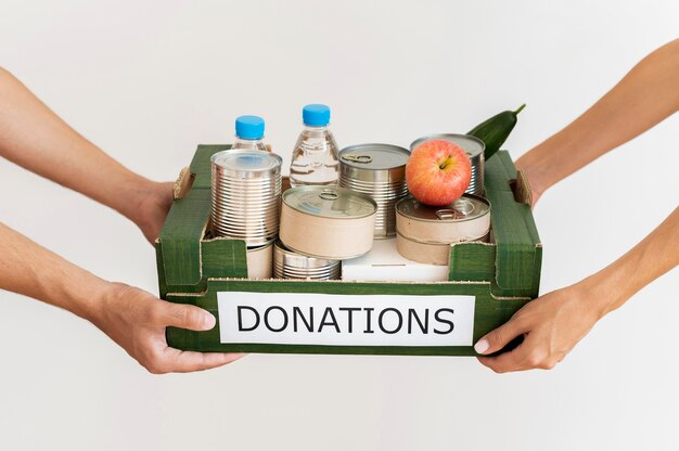 Hands holding donation box with provisions