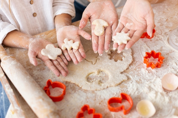 Free photo hands holding dough shaped in forms