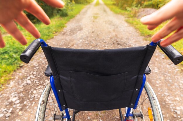 人のための患者サービス車椅子を待っている病院公園で空の車椅子を持っている手..。