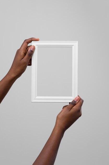 Hands holding empty white frame