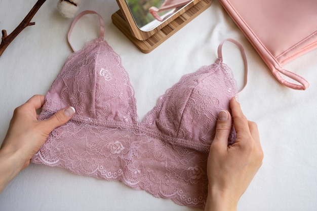 Foto gratuita mani che tengono il reggiseno femminile ancora in vita