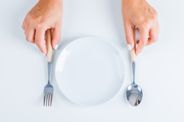 Hands holding fork and spoon