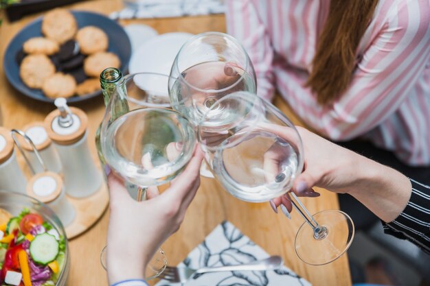 Hands holding glasses of wine together