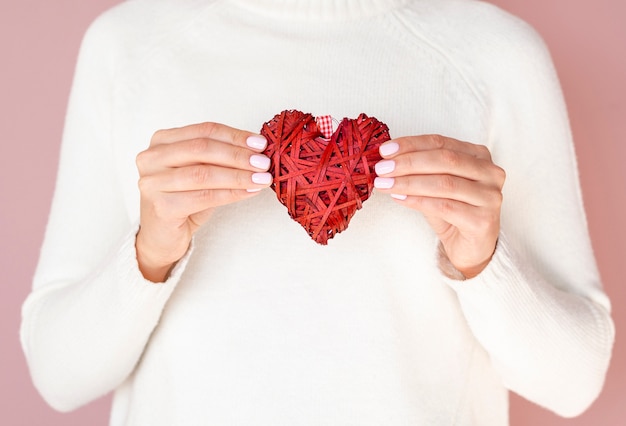 Foto gratuita mani che tengono vista frontale della decorazione del cuore