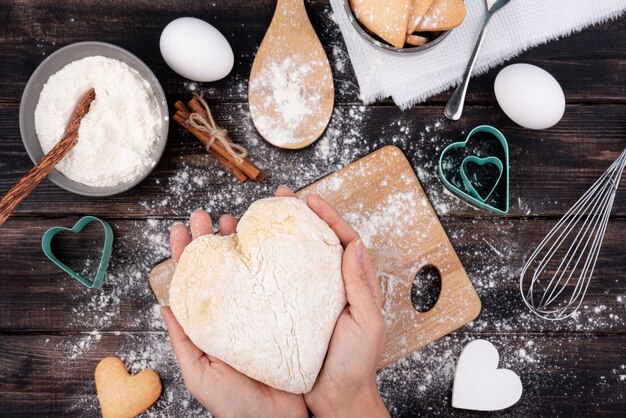 Hands holding heart-shaped dough