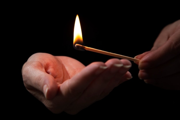 Free photo hands holding lit matches low angle