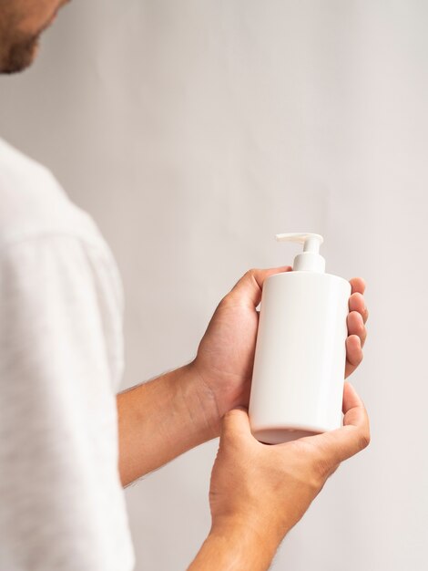 Hands holding lotion bottle mock-up