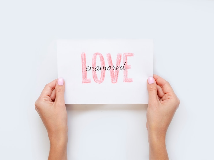 Free Photo hands holding love paper flat lay