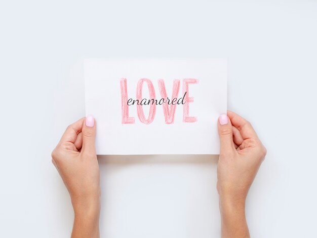 Hands holding love paper flat lay