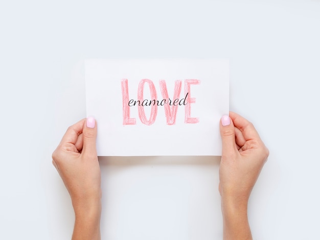 Hands holding love paper flat lay