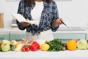 Free photo hands holding a notebook next to vegetables