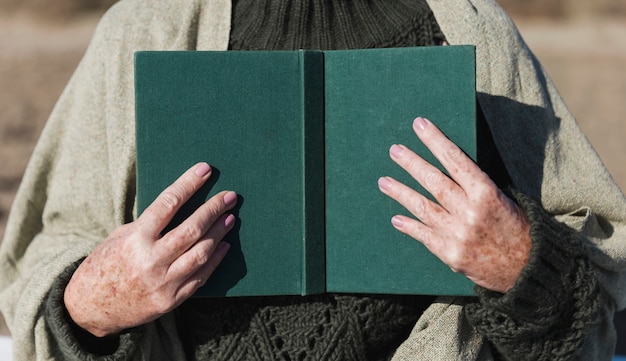 Hands holding open book front view