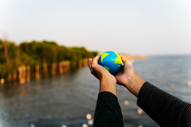 Hands holding out a small globe