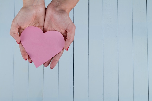 Free photo hands holding paper heart