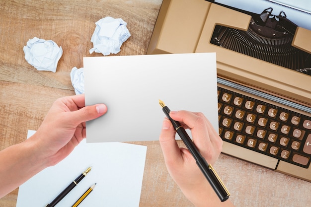 Hands holding a paper with typewriter background