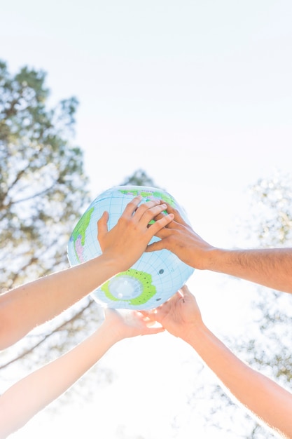Free photo hands holding planet model in nature